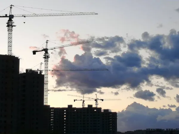 silhouette of a building with a crane