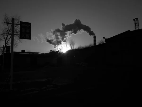 black and white smoke on the background of the industrial building