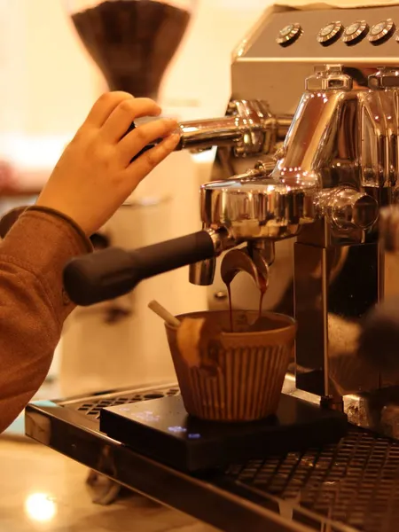 barista pouring coffee into a cup