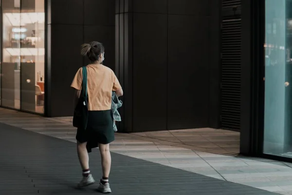 young woman with backpack walking in the city