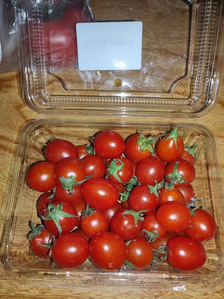 fresh tomatoes in a box on a wooden table