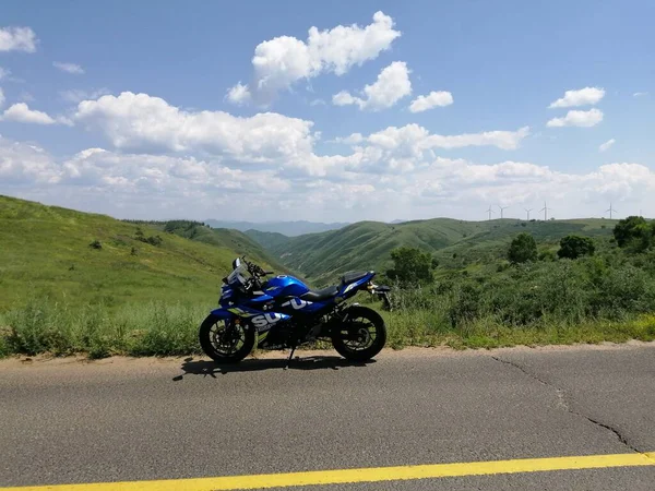 a man in a white t-shirt is riding a motorcycle in the mountains