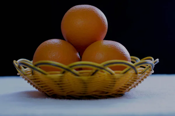 fresh orange and black and white photo of a whole and half of a ripe juicy oranges on a dark