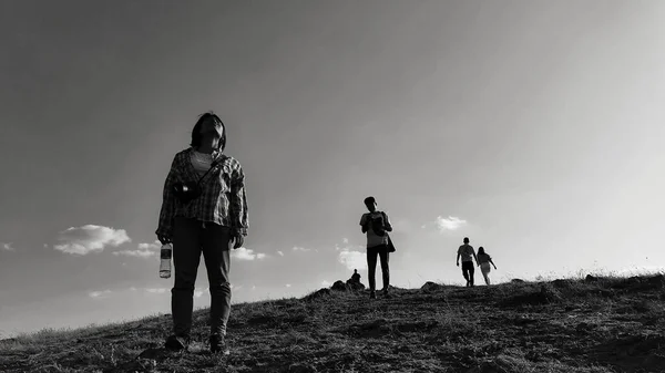 silhouette of a man and woman with backpacks on the top of the mountain