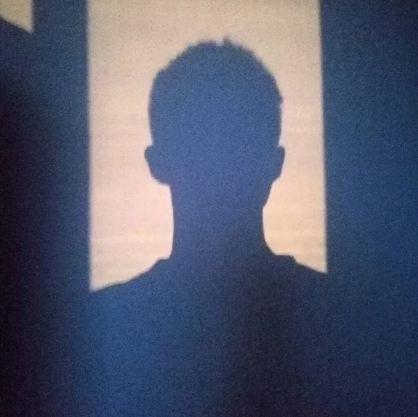 silhouette of a man in a black t-shirt on a light background