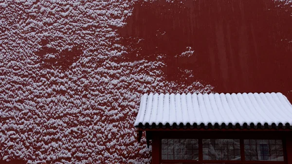 red and white snow on the roof of the house