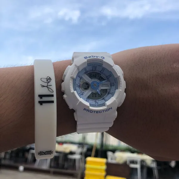 close up of a white smart watch on a background of a city.