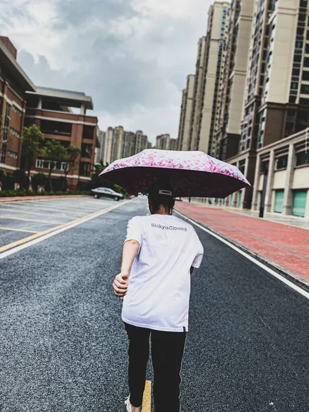 young woman with umbrella walking on the street