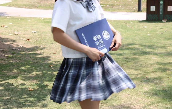 girl with backpack and book on the background of the university