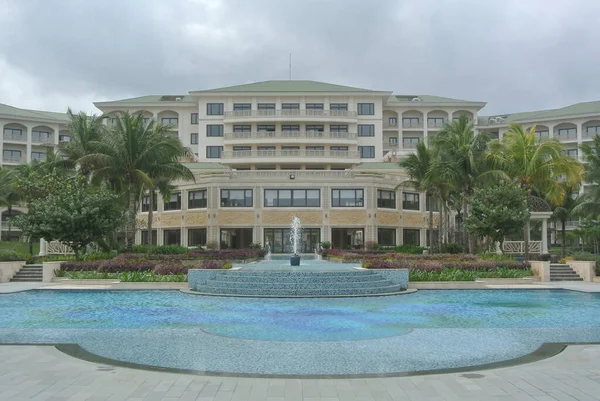 swimming pool with green grass and palm trees