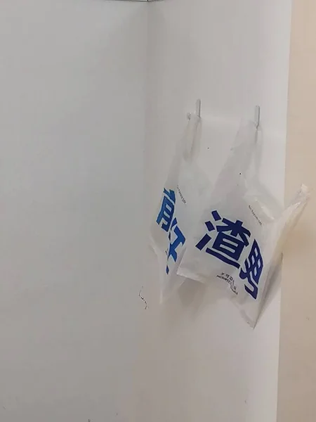 white paper bag with a red handle on a background of a wall