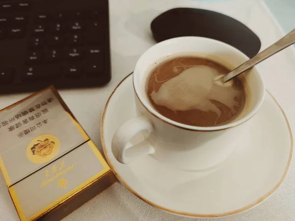 cup of coffee and a notebook on a white background