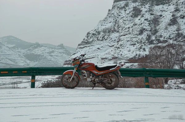 the snow-covered motorcycle in the mountains