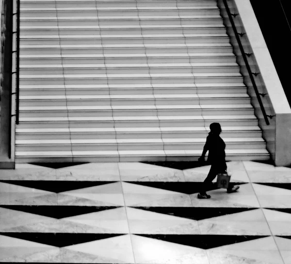 silhouette of a man in a black suit and a white shirt walking on the stairs