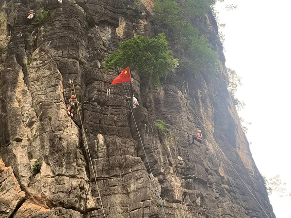 young woman climbing the rock in the mountains