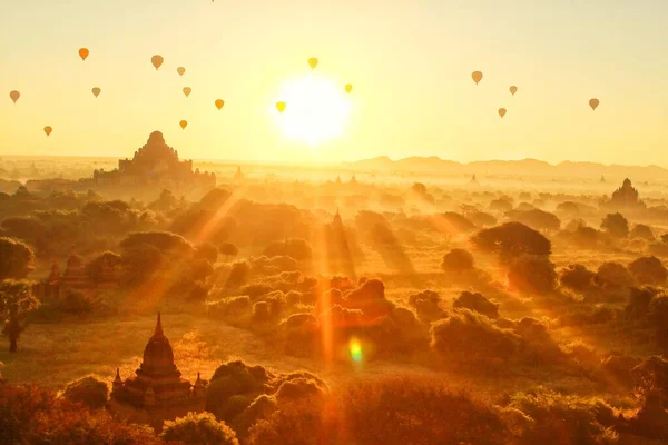 the temples of bagan in the morning fog, the sun rises through the clouds