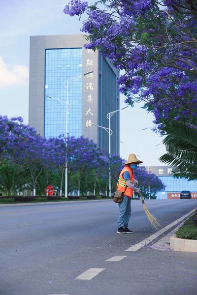 a young man in a blue shirt and a jacket walks in the city