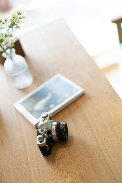 vintage camera with a bouquet of flowers and a book on a wooden table