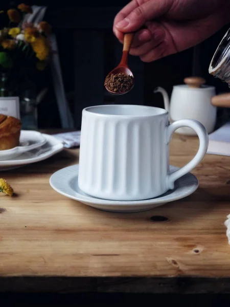 a piece of cake with a cup of coffee and a black background