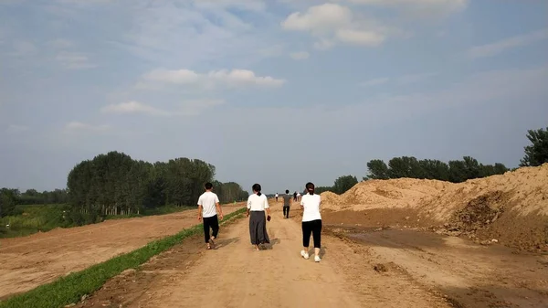 a group of people walking in the field