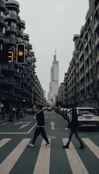 a young man in a suit with a backpack walking on the street