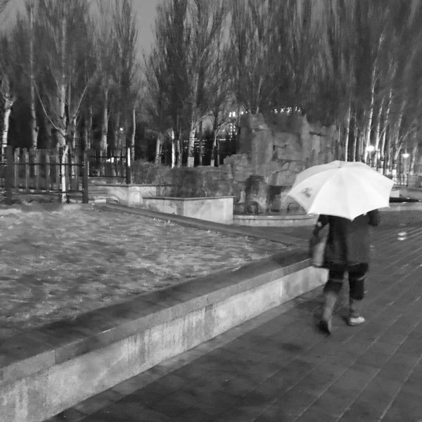young man walking in the rain