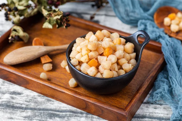 bowl with tasty corn and nuts on wooden background