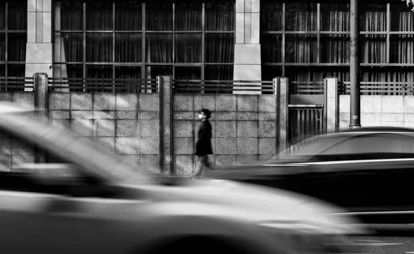 black and white photo of a man in the city