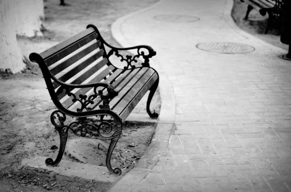 stock image black and white photo of a young woman sitting on a bench in the park