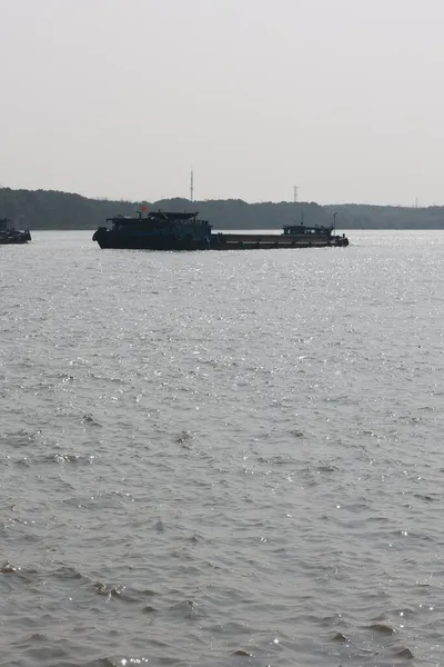 the ship is a large cargo boat on the shore of the sea.