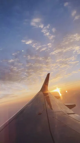 stock image wing of airplane flying above the window