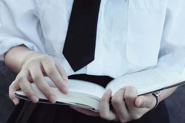 close-up of a woman reading book in hands