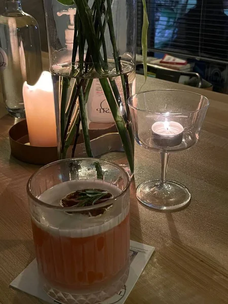 a glass of wine and a candle in a restaurant