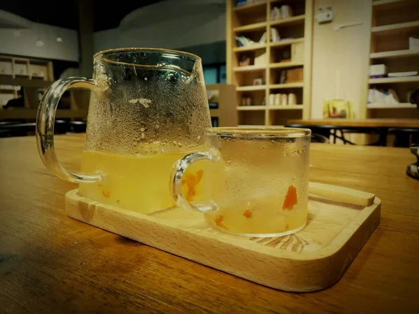 glass of beer with ice on wooden table