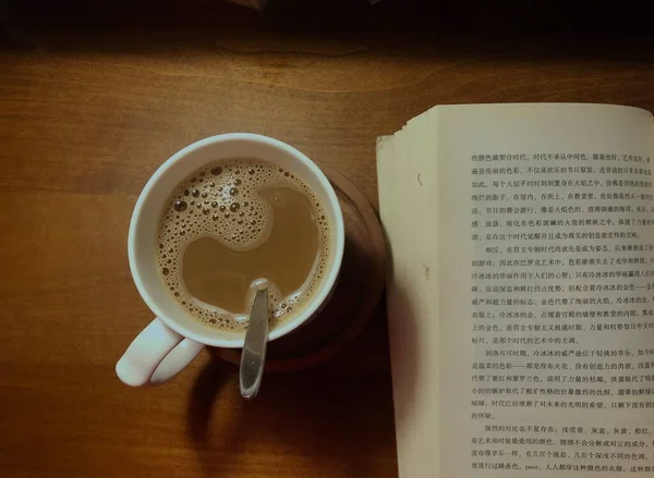 cup of coffee and a book on a wooden background