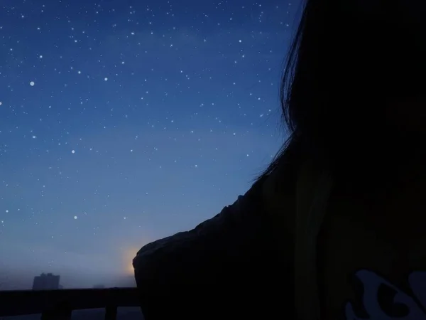 silhouette of a woman in a night sky
