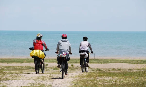 a group of people riding a bike on the beach