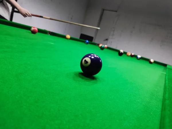 billiard table with cue and pool ball