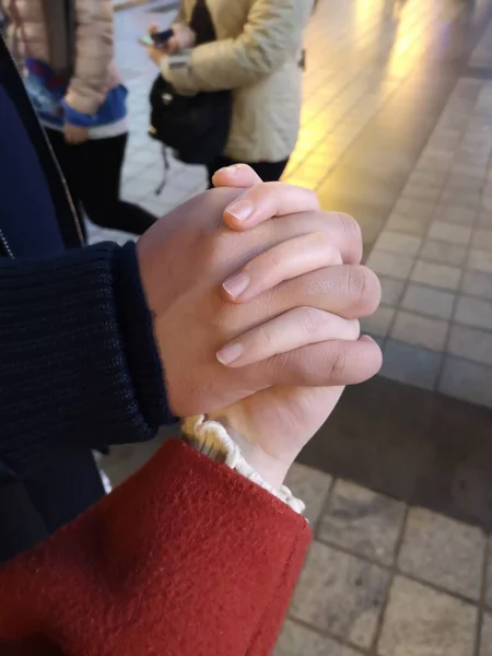 hands of a man and a woman in a black dress with a white background