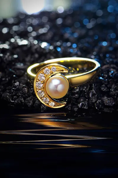 gold ring with precious stones on a black background