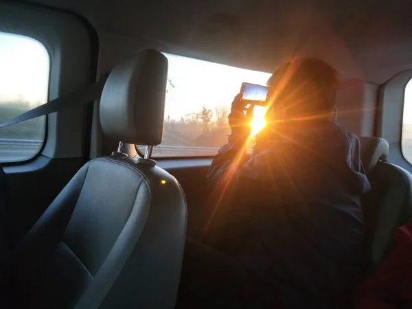 rear view of a young man driving a car