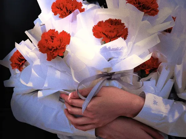 a closeup shot of a female doctor with a bouquet of flowers