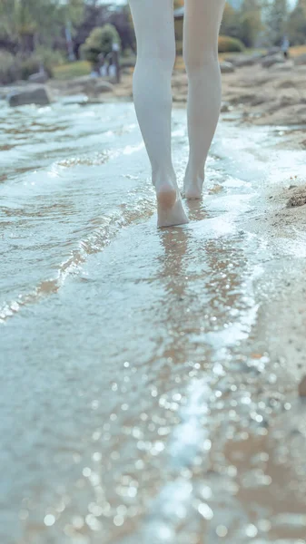 woman legs in wet water on the beach