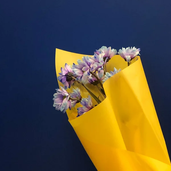 bouquet of flowers and paper bag on a blue background