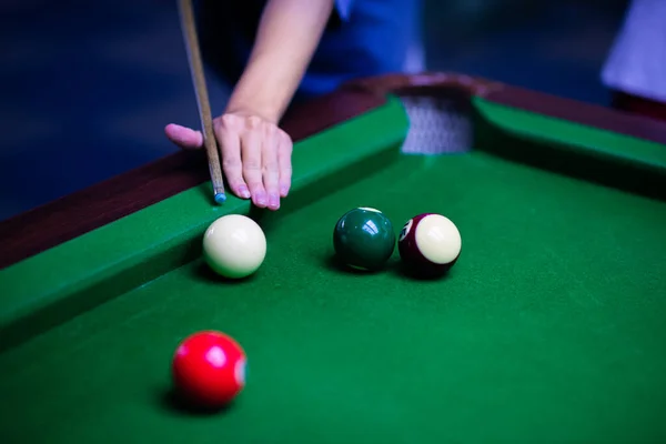 woman playing billiards with cue and pool