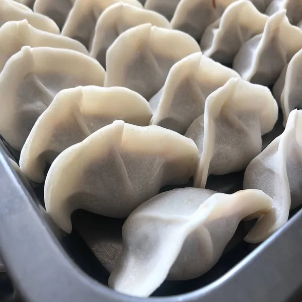 close up of a bowl of raw dumplings