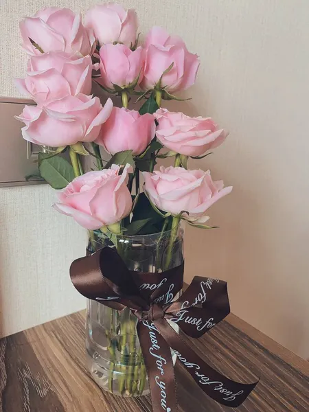 beautiful bouquet of roses in a vase on a wooden background