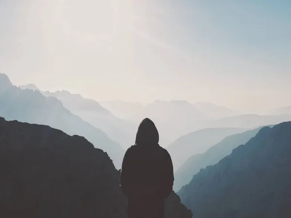 man in a suit with a backpack on the top of the mountain