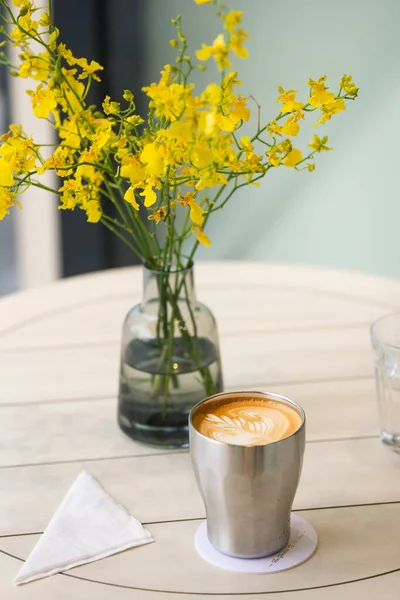 cup of coffee and flowers on table