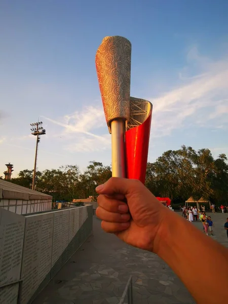 hand holding a wooden bucket with a red umbrella